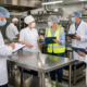 Auditoría en cocina industrial con mesas de acero inoxidable cumpliendo normas de sanidad en México